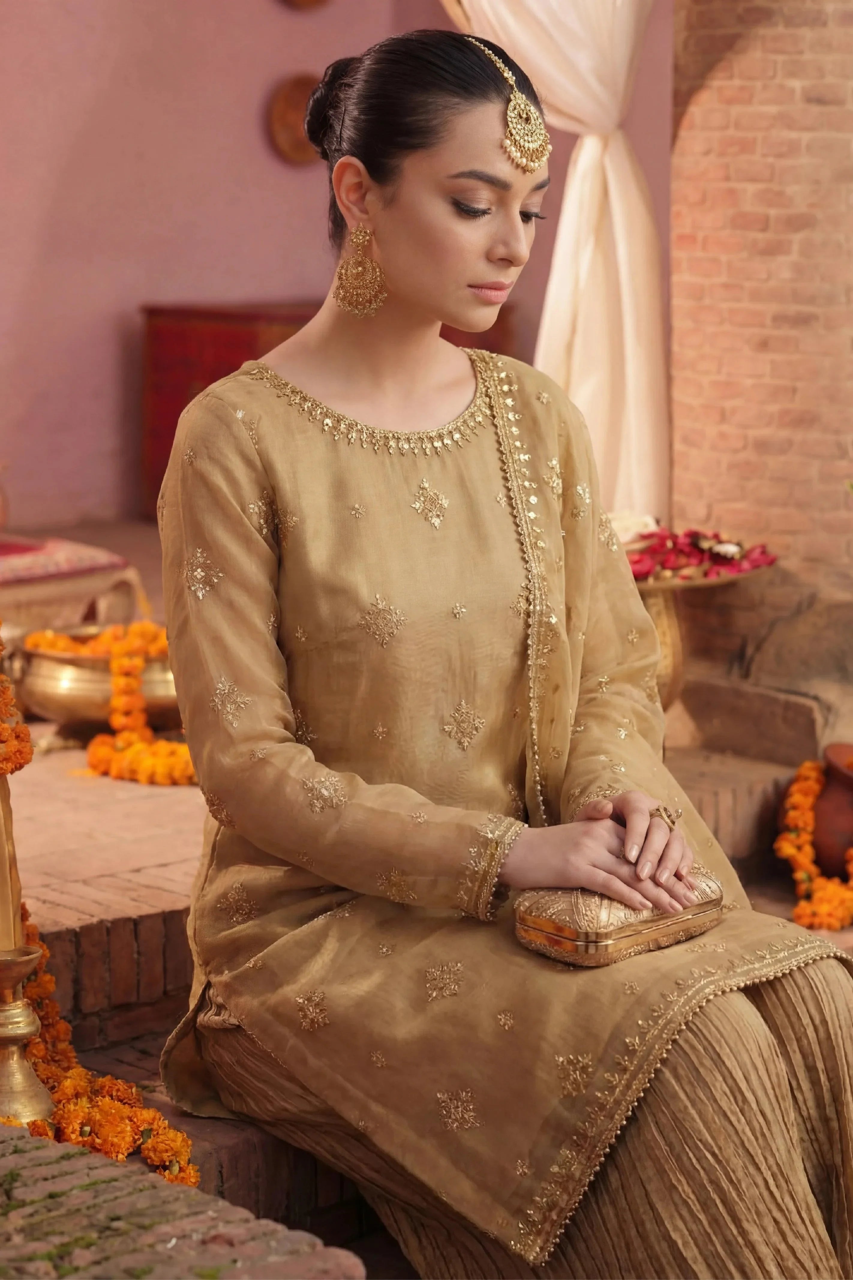Elegant gold embroidered Pakistani dress with traditional jewelry for wedding or festive occasions