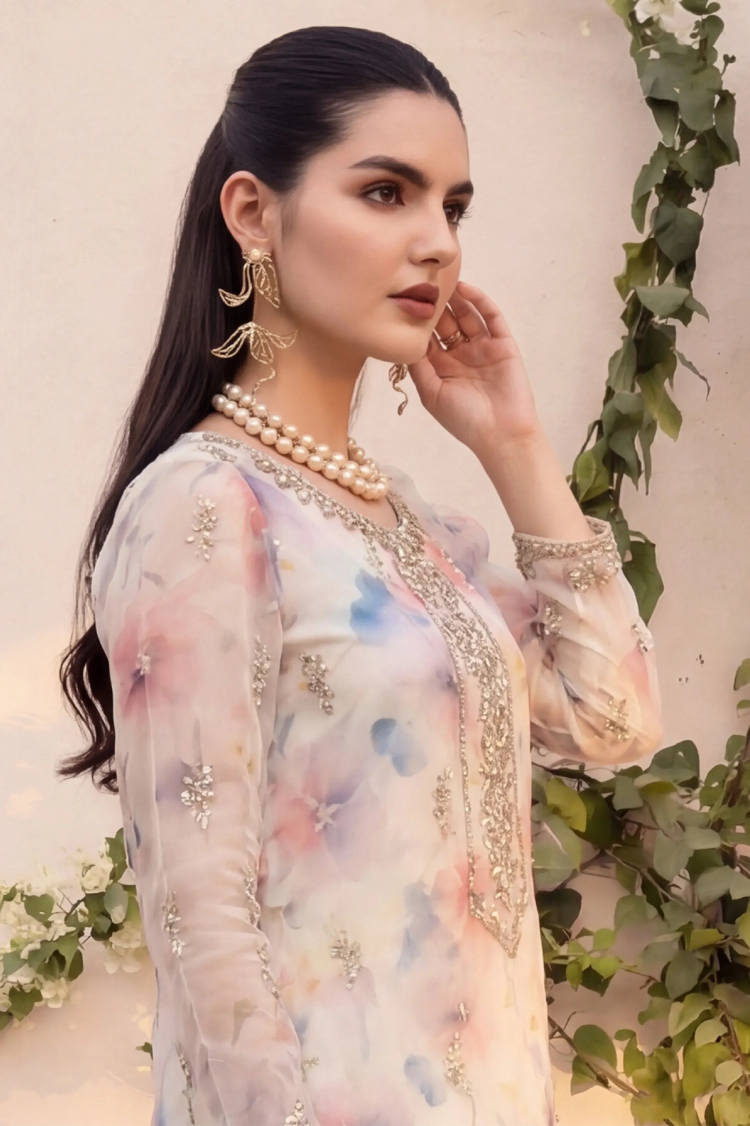 Elegant floral embroidered dress with pearl jewelry, perfect for special occasions in Pakistan.