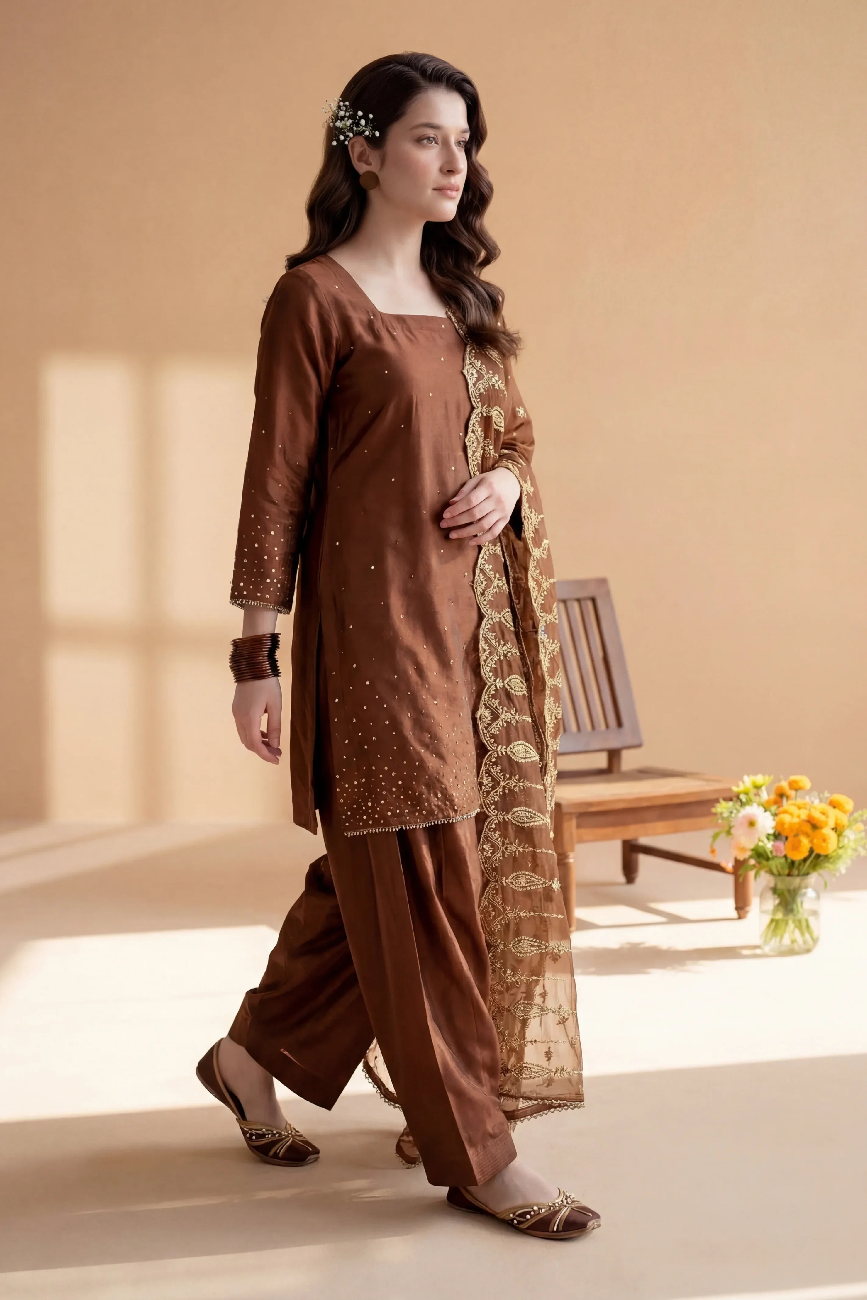 Brown embroidered Pakistani suit with gold detailing, perfect for elegant occasions and traditional wear.
