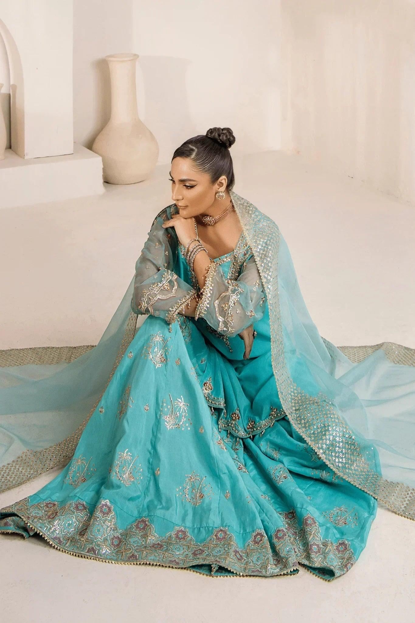Elegant turquoise embroidered Pakistani dress with gold detailing, perfect for weddings and formal events.