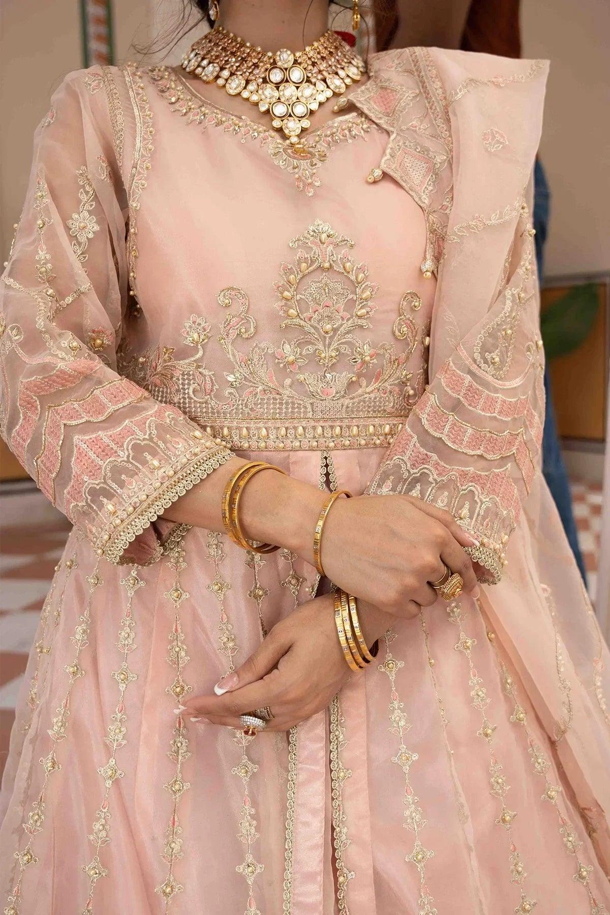 Pink embroidered bridal dress with gold detailing, matching jewelry, and sheer sleeves for Pakistani women&