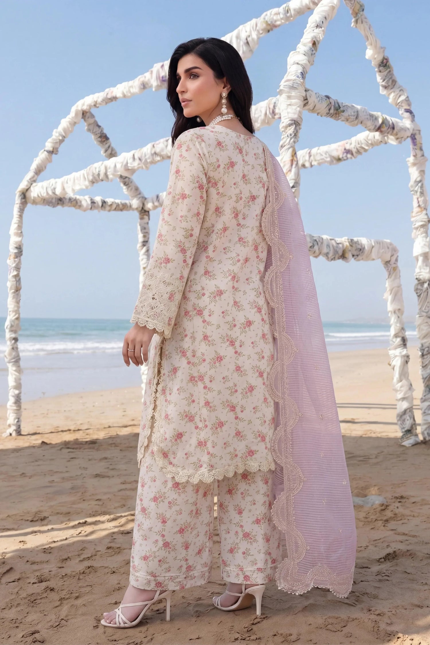 Floral printed stitched dress with lace detailing and pink dupatta, beach setting