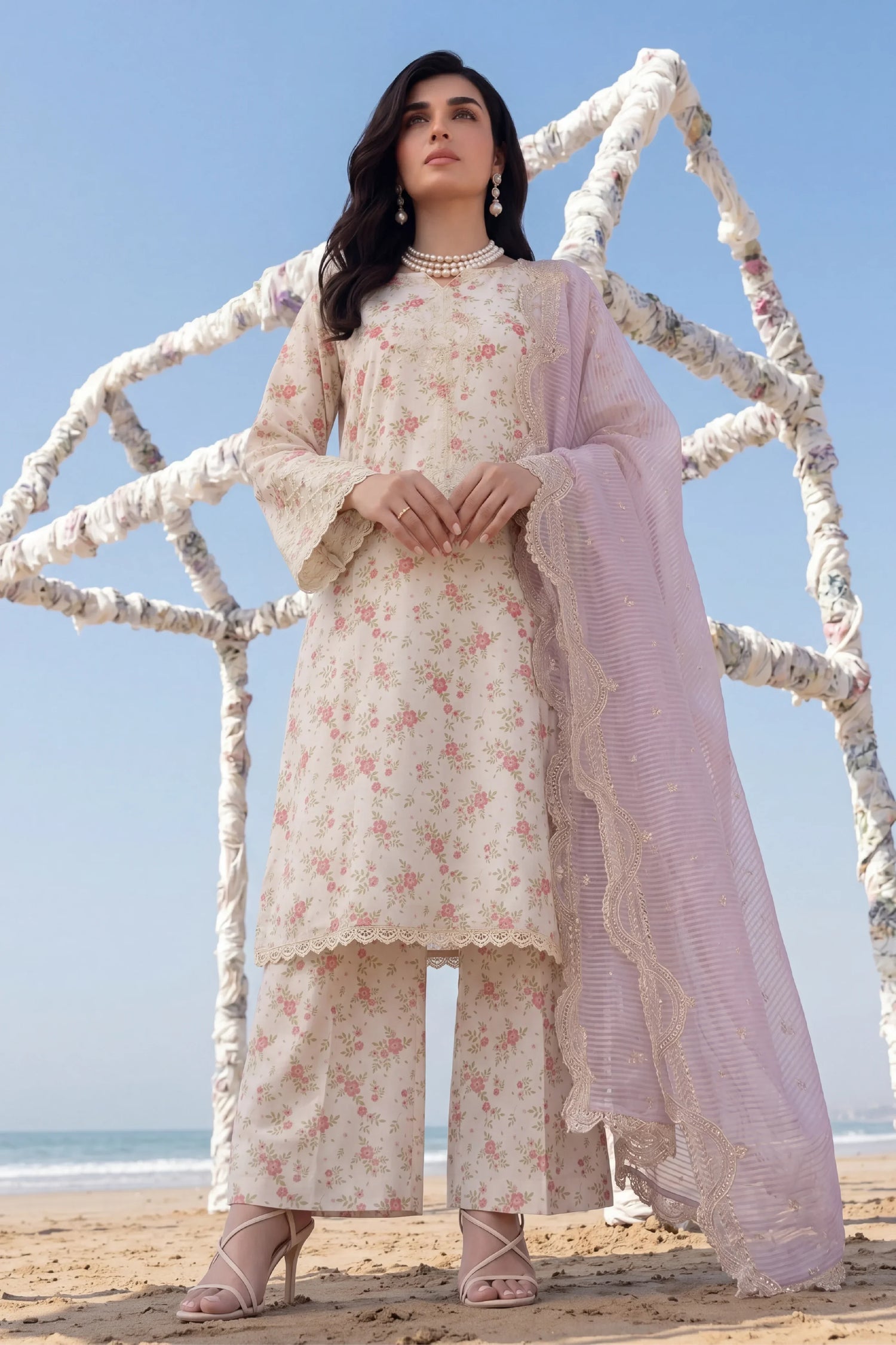 Floral printed stitched dress with lace detailing, paired with sheer dupatta, beach setting