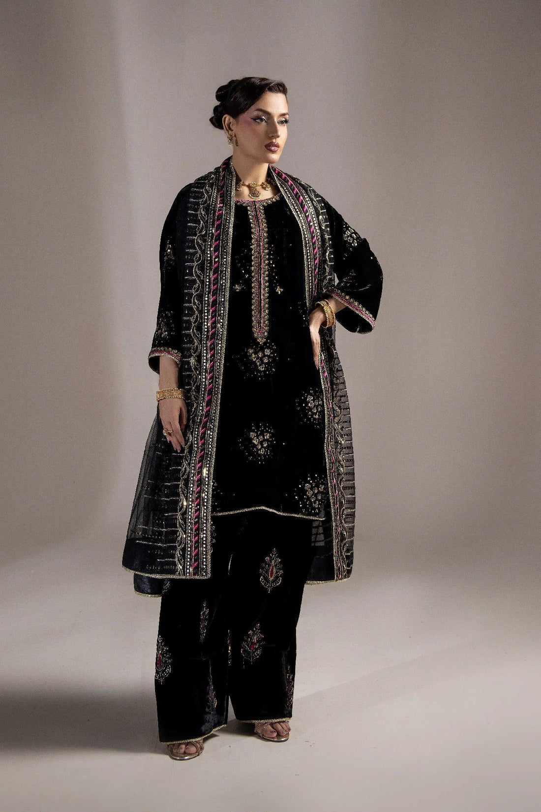 Elegant black velvet embroidered dress with gold and pink detailing, perfect for Pakistani women&