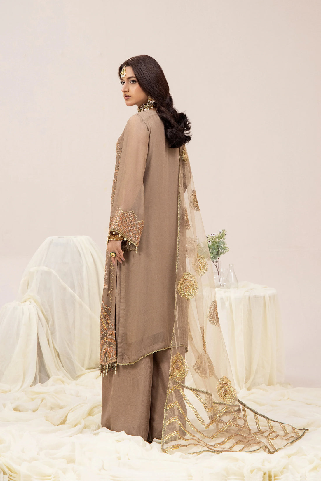 Elegant beige Pakistani dress with gold embroidery, sheer dupatta, and matching palazzo pants for women.