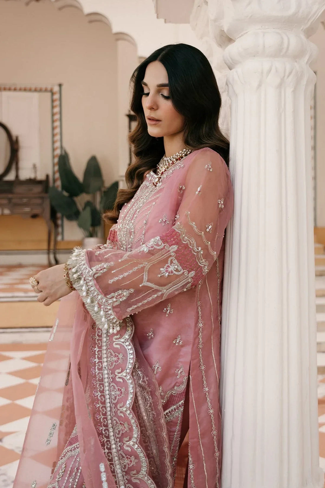 Elegant pink embroidered Pakistani dress with intricate lace and pearls, perfect for special occasions.