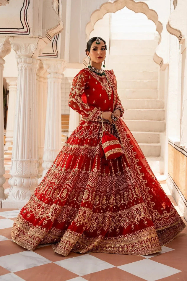 Woman in a red and gold traditional outfit standing in an ornate architectural setting.